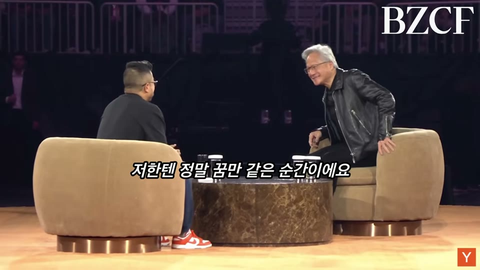 젠슨 황이 무대에 올라 진행자와 인사를 나누는 장면